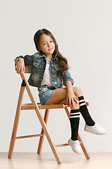 Image showing Full length portrait of cute little kid in stylish jeans clothes looking at camera and smiling