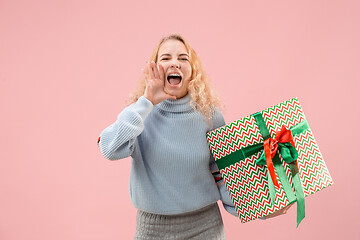 Image showing Woman with big beautiful smile holding colorful gift box.