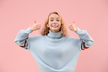 Image showing The happy business woman standing and smiling against pink background.