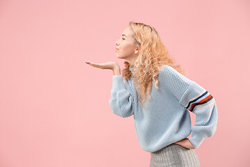 Image showing Portrait of attractive cute girl with bright makeup with kiss isolated over pink background