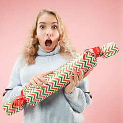 Image showing Woman with big beautiful smile holding colorful gift box.