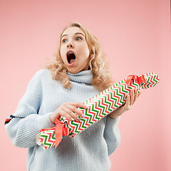 Image showing Woman with big beautiful smile holding colorful gift box.