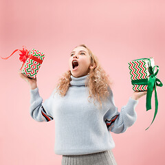 Image showing Woman with big beautiful smile holding colorful gift boxes.