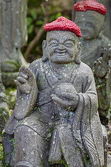 Image showing Old stone statues of Buddhist monks and nuns wearing knitted and cloth hats