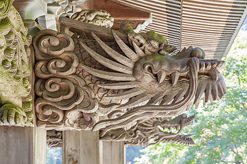 Image showing Wooden carving of dragon decorates the gable of a roof over the entrance of an ancient Buddhist temple in Japan.