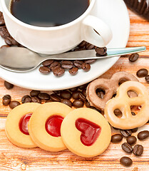 Image showing Mug of freshly brewed coffee and heart cookies 