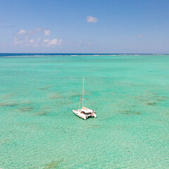 Image showing Catamaran sailing boat in turquoise sea lagoon on tropial Mauritius island. Aerial, drone view.