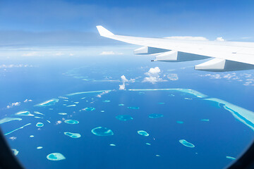 Image showing Top view of Maldive islands from airplane window with airplane\'s wing