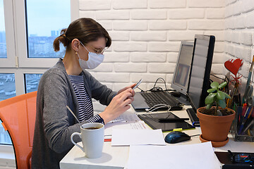 Image showing A sick girl in a medical mask at home communicates on the phone