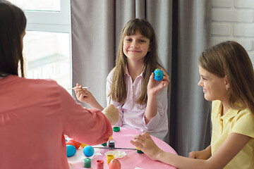 Image showing Happy girl shows a painted easter egg