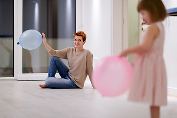 Image showing mother and cute little daughter playing with balloons