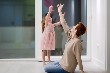 Image showing mother and cute little daughter playing with balloons