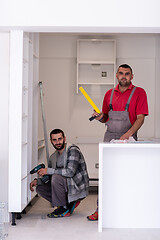 Image showing young workers installing a new kitchen