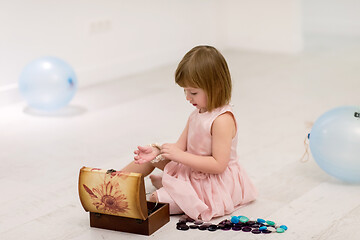 Image showing little girl enjoying while playing with mother\'s jewelry