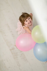 Image showing cute little girl playing with balloons