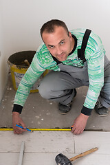 Image showing worker installing the ceramic wood effect tiles on the floor