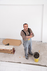 Image showing worker installing the ceramic wood effect tiles on the floor