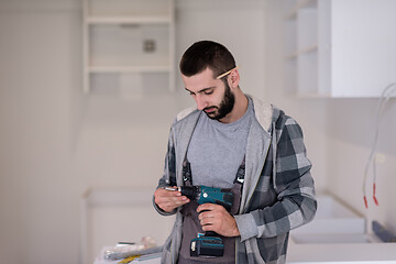 Image showing the worker holding a hand drilling machine