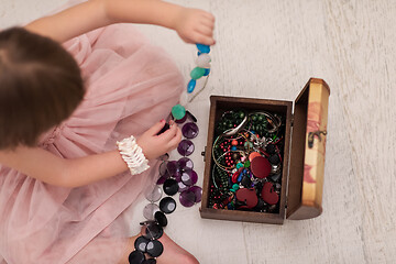 Image showing little girl enjoying while playing with mother\'s jewelry