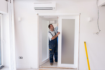 Image showing carpenters installing glass door with a wooden frame