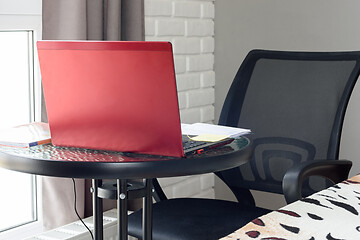 Image showing A table on which there is a laptop and textbooks are laid out in the home interior