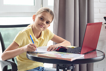 Image showing The girl was distracted from the online lesson and looked into the frame