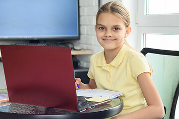 Image showing Happy girl sitting in front of a laptop and studying remotely