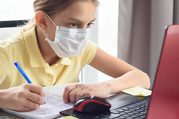 Image showing Girl in a protective mask remotely watch training services