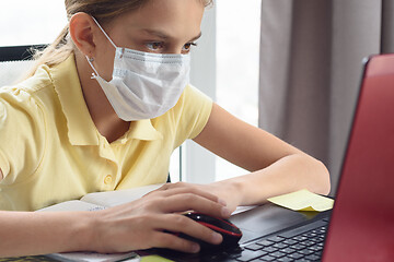 Image showing Girl in medical mask is studying at the computer.