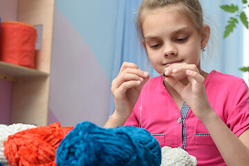 Image showing Girl strung a bead on a needle embroidering toys