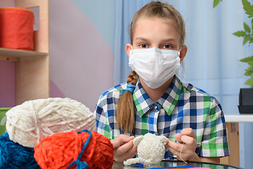 Image showing A girl in quarantine self-isolation is engaged in knitting