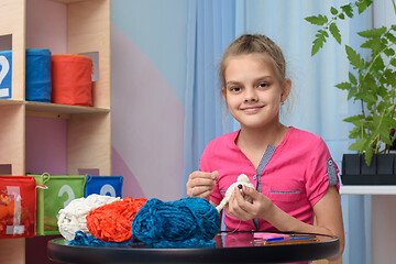 Image showing The girl is engaged in embroidery of soft toys at home
