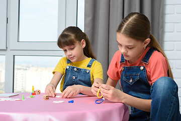 Image showing Two girls play games at the table