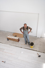 Image showing worker installing the ceramic wood effect tiles on the floor