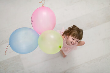 Image showing cute little girl playing with balloons