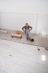 Image showing worker installing the ceramic wood effect tiles on the floor