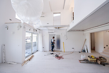 Image showing carpenters installing glass door with a wooden frame