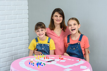 Image showing Happy family having fun laughing while playing board games at a table