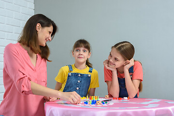 Image showing Girl made a funny face playing board games with mom and sister