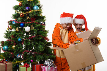 Image showing The girl funny holds a box with New Year\'s toys, another girl delves into a box