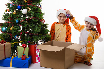 Image showing Children show what a beautiful ball they found in a box with New Year\'s toys.