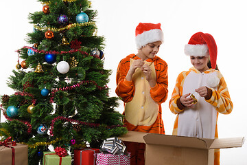 Image showing Girls examine New Year\'s toys decorating the Christmas tree