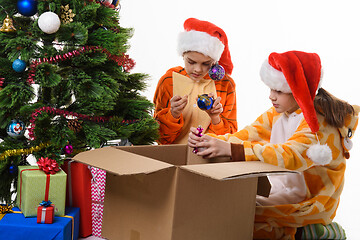 Image showing Children make out a box with New Year\'s toys