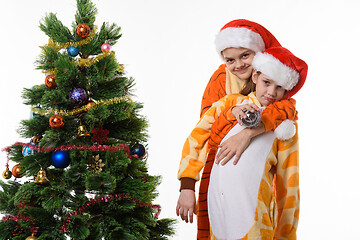 Image showing Girl hugs another girl near the New Year tree