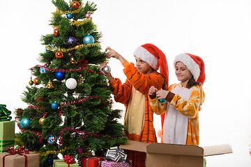 Image showing Two girls decorate a Christmas tree isolated on white background