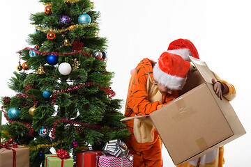 Image showing One girl holding a box, another girl looking for Christmas toys in a box