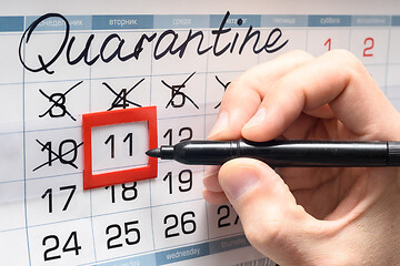 Image showing A hand crosses out the next day on the calendar during the quarantine period