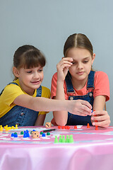 Image showing Two girls enthusiastically play a board game