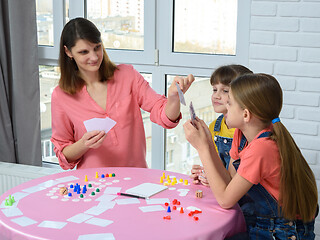 Image showing Girl picks up a card from a pile of daughter cards in a board game