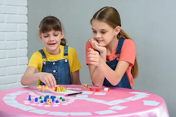 Image showing Two girls at the table play a board game